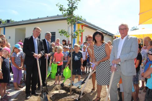 Landtagsabgeordneter Aloysius Mikwauschk, Landrat Michael Harig, Schulleiterin Simone Kolata, Bürgermeisterin Kerstin Ternes und Ortsvorsteher Christian Schöne (v.l.n.r.) pflanzten gemeinsam mit den Kindern als Erinnerung an die Einweihung den neuen Schulbaum