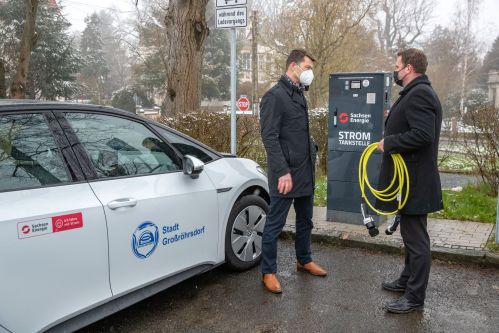 Gunnar Schneider (li.) von SachsenEnergie und Bürgermeister Stefan Schneider (re.) an der öffentlichen Ladesäule auf dem großen Parkplatz hinter dem Rathaus. 